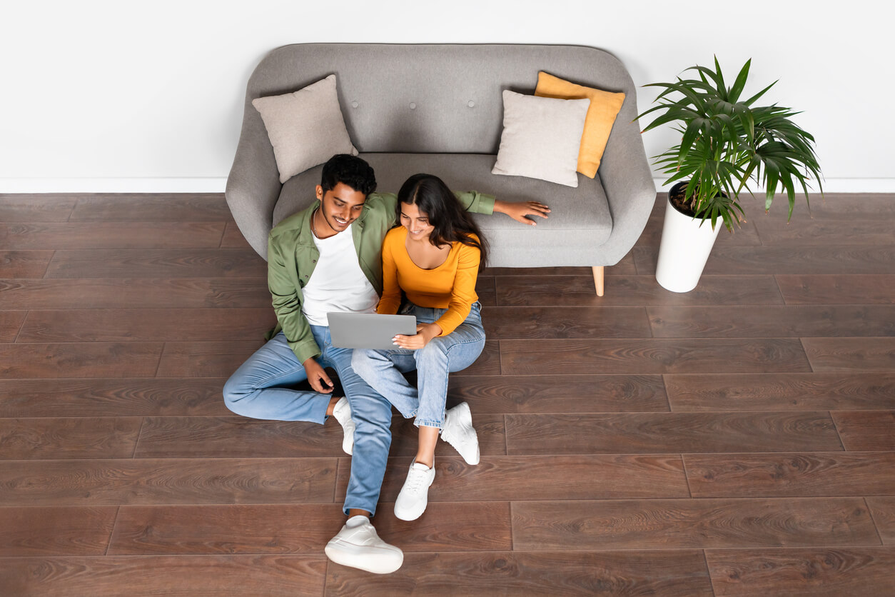 couple in their living room on computer for an online couples therapy session
